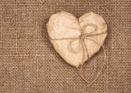 paper heart on a burlap, as a  backgroundの写真素材