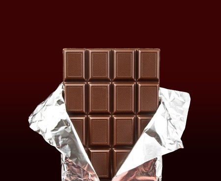 chocolate bar with open cover on dark background