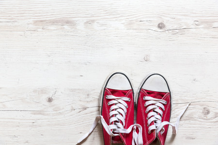 Old red shoes on wooden backgroundの写真素材
