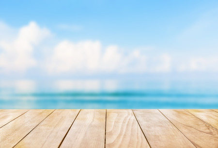 Wooden table top on blue sea and white sand beach backgroundの写真素材
