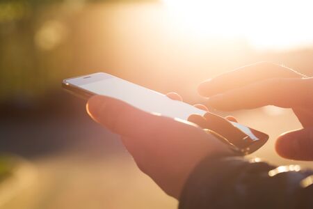 Man using his Mobile Phone outdoor, close upの写真素材