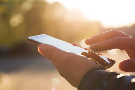 Man using his Mobile Phone outdoor, close upの写真素材