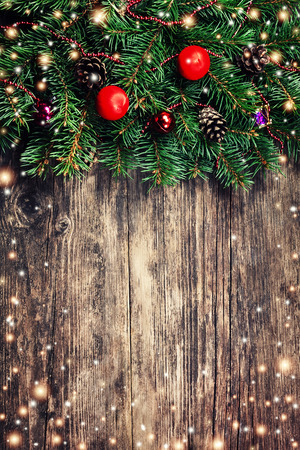 Christmas fir tree branches with toys on old wooden tableの写真素材