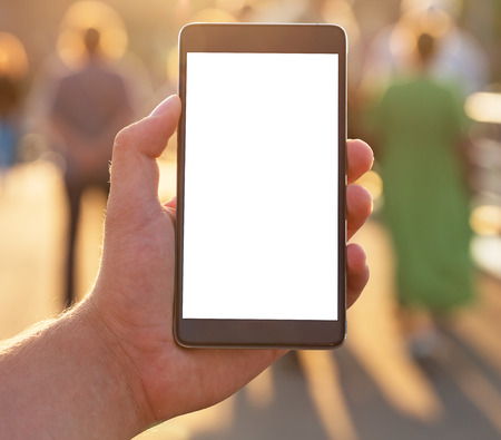 Man uses his Mobile Phone outdoor, close up. Man using mobile smart phone with blank white screen.の写真素材