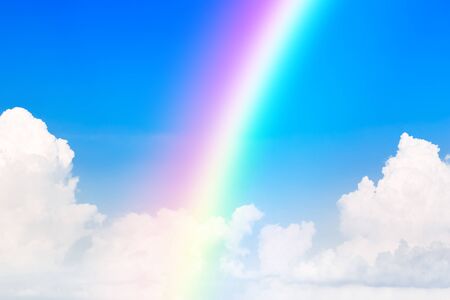 Blue sky and white cloud and rainbow. A bright rainbow background.の写真素材