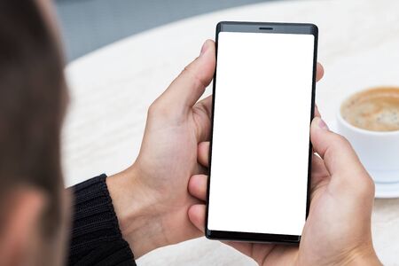 Close up of man's hands holding mobile smart phone with blank copy space screen. Image of man...