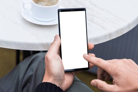 Close up of man's hands holding mobile smart phone with blank copy space screen. Image of man...