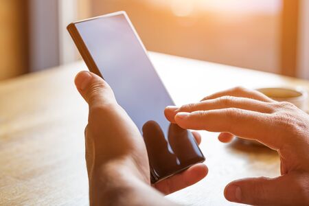 Close up of man's hands holding mobile smart phone with blank copy space screen. Image of man...