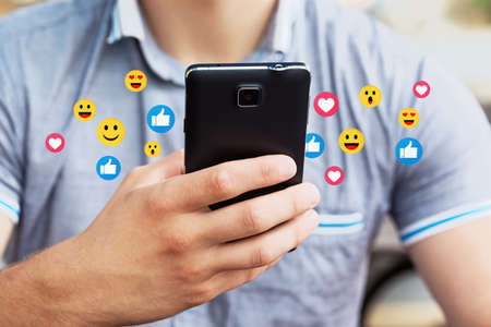 Man using mobile smart phone, close up. Picture of young man using a mobile smart phone and smiling.