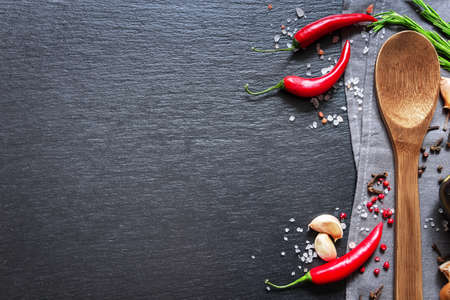 Food ingredients on dark background. Spices, garlic and pepper on black background. Vegetarian food, health or cooking concept.の写真素材