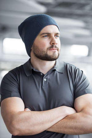 Portret a handsome young man with beard looking out the window. Image of happy man wearing formal clothes over gray background.の写真素材