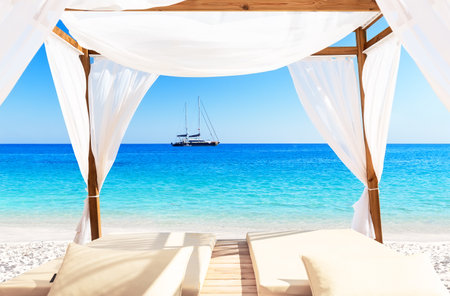 View of a beautiful beach through a Balinese bed. Nice tropical white sandy beach with bed in Punta Cana, Dominican Republic. Vacation holidays sammer background.の写真素材
