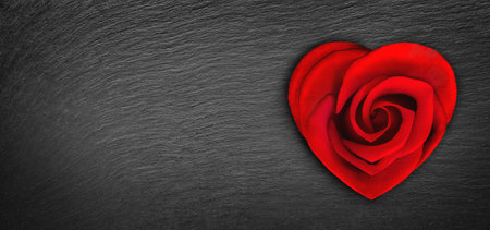 Rose flower in heart shape on dark background with heart shaped bokeh light. Valentine's day celebration. Heart shaped red rose, concept of Valentine's, anniversary, mother's day and birthday greeting, copy space.の写真素材
