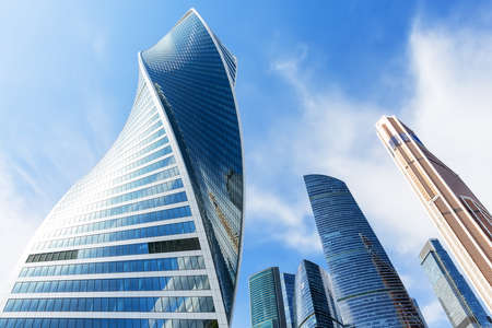 Modern glass silhouettes of skyscrapers in the city. Bottom view of modern skyscrapers in business district.の写真素材