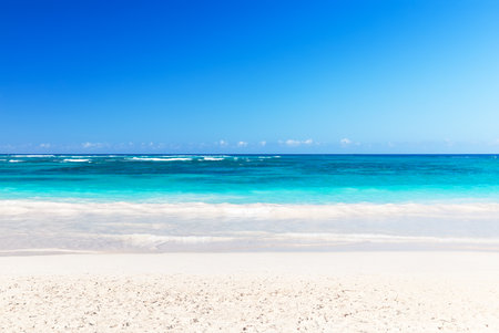 Landscape view of beautiful tropical white sand beach and turquoise sea in sunny day in Punta Cana, Dominican Republic. Empty tropical beach background. Horizon with sky and white sand.の写真素材