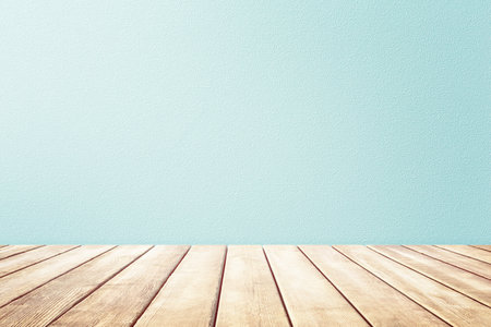 Empty wooden deck table and mint wallpaper background for present product. Empty table top, light rays from the window on the background of the wall. For product demonstration.の写真素材
