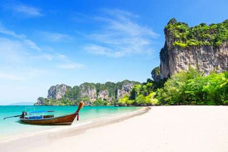 Thai traditional wooden longtail boat and beautiful white sand Railay Beach in Krabi province, Ao Nang, Thailand. Amazing view of beautiful beach with long tail boat in Railay beach, Krabi, Thailand.の写真素材