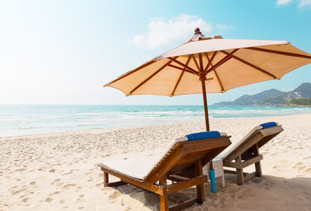 Two lounge chairs with sun umbrella on a white sand Chaweng beach in Koh Samui, Thailand.の写真素材