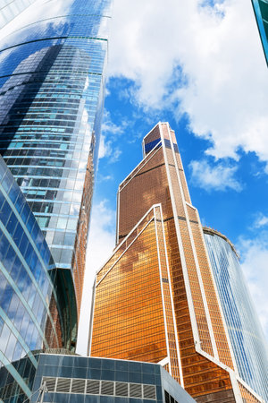 Low angle view of modern skyscrapers against blue sky. Reflective skyscrapers, business office buildings.の写真素材