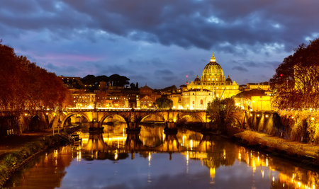 Beautiful image of St. Peter's Basilica, Ponte Sant Angelo and Tiber River at dark night in Rome, Italy. Sant' Angelo Bridge and St. Peter's cathedral at sunset in Vatican City, Rome, Italy.の写真素材