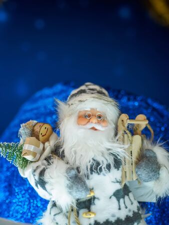 A toy Santa Claus standing against starry dark blue background. Christmas and New Year concept.の写真素材