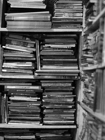 BLACK AND WHITE PHOTO OF BOOKS CRAMMED IN BOOKSHELFの写真素材
