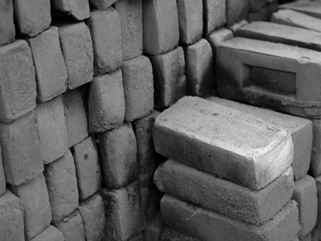 BLACK AND WHITE PHOTO OF PILE OF RED CLAY BRICKSの写真素材