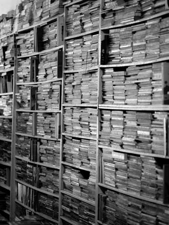 BLACK AND WHITE PHOTO OF BOOKS CRAMMED IN BOOKSHELVES AT BOOKSTOREの写真素材
