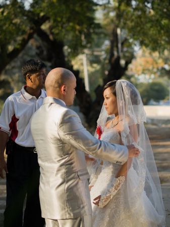 MANDALAY, MYANMAR - JANUARY 01, 2013: GROOM TIDYING BRIDE'S DRESSのeditorial素材