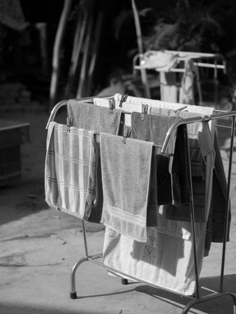 BLACK AND WHITE PHOTO OF GROUP OF TOWELS UNDER SUNLIGHT