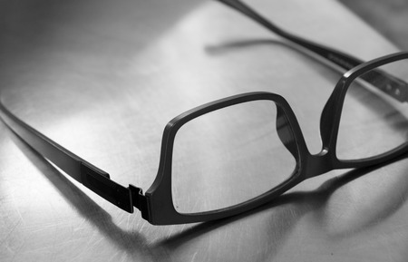 PLASTIC FRAME GLASSES ON STEEL TABLEの写真素材