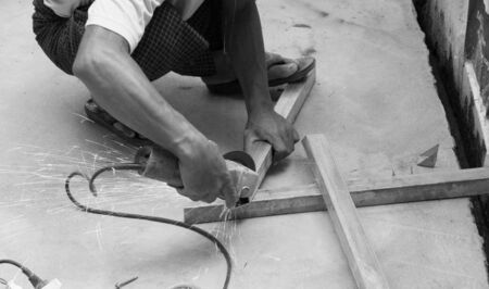 WORKER CUTTING STEEL WITH ELECTRIC WHEEL GRINDERの写真素材