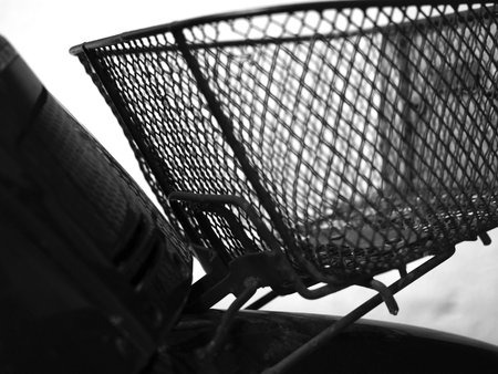 BLACK AND WHITE PHOTO OF BLURRY SHOT OF MOTORCYCLE FRONT METAL BASKETの写真素材