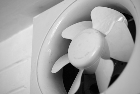 BLACK AND WHITE PHOTO OF EXHAUST FAN MOUNTED ON WALLの写真素材