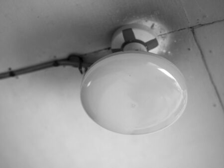 BLACK AND WHITE PHOTO OF CLOSE-UP OF ROUNDED CEILING LIGHTの写真素材