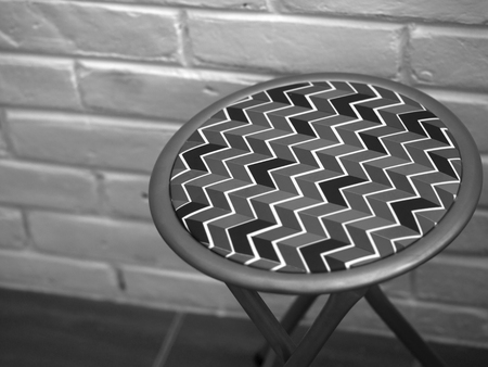 BLACK AND WHITE PHOTO OF STOOL WITH ZIG ZAG PATTERN LEATHERの写真素材