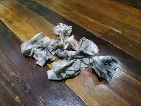 Dirty cloth-like crumpled wet wipes on wooden floor