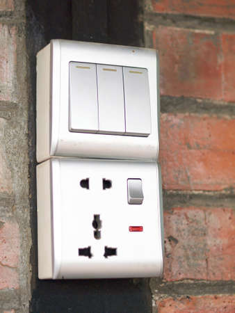 Three-key switch gray on the wall a plastic mechanical switch. The concept of energy savings....