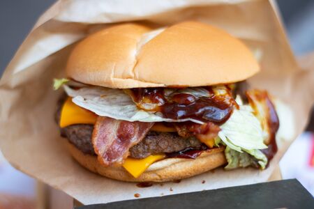 A hamburger is a sandwich consisting of one or more cooked patties of ground meat, usually beef, placed inside a sliced bread roll or bun.の写真素材