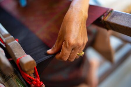 Weaving is a method of textile production in which two distinct sets of yarns or threads are interlaced at right angles to form a fabric or cloth.の写真素材