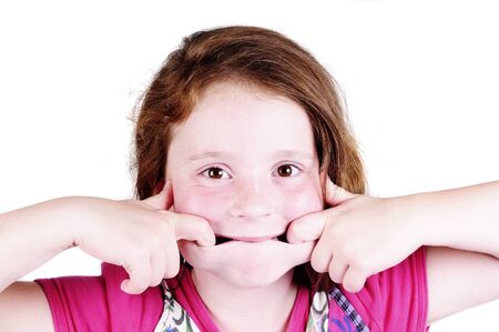 redhead girl pulling a funny face on a white backgroundの写真素材