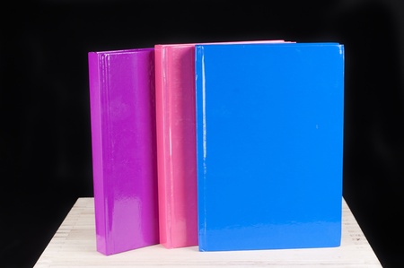 three colorful books on a black backgroundの写真素材