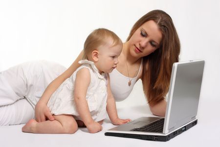beautiful mother with daughter looking on the laptopの写真素材