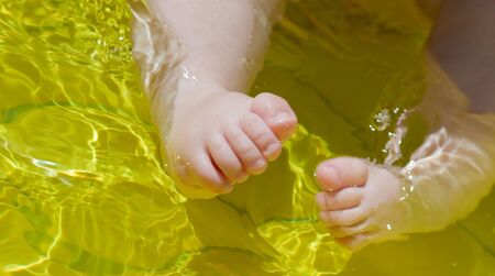 closeup baby's feet in waterの写真素材