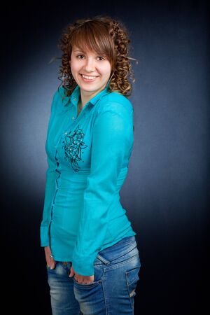 A happy young woman with big smile on dark backgroundの写真素材