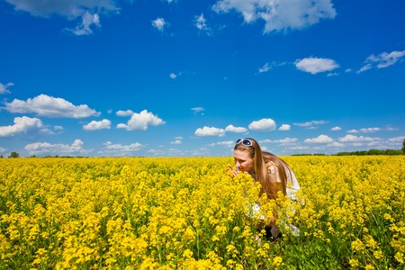 young happy girl in yellow flowersの写真素材