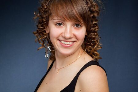 A happy young woman with big smile on dark backgroundの写真素材