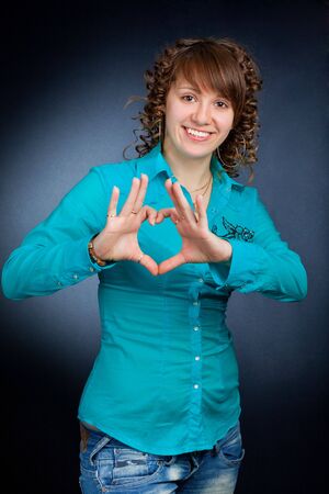 form of heart shaped by the hands of a beautiful young womenの写真素材