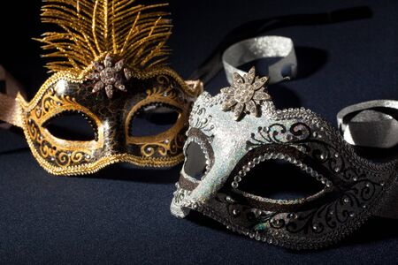 silver and black carnival masks isolated on a black backgroundの写真素材