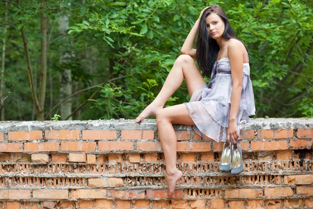 girl sitting on old wallの写真素材